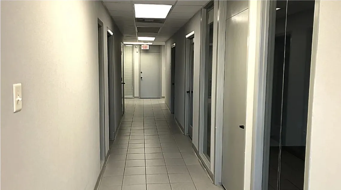 Interior corridor in Building A lined with private office doors and glass sidelights.